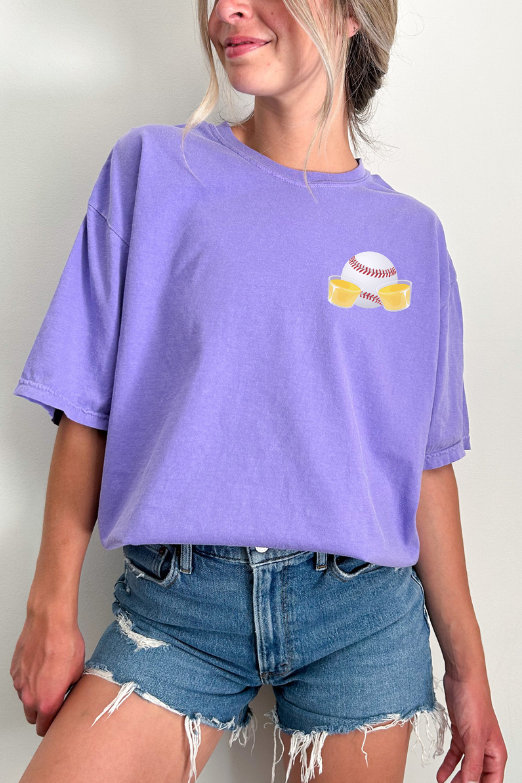 woman wearing a purple t-shirt with a graphic on the left chest of a baseball and jello shots