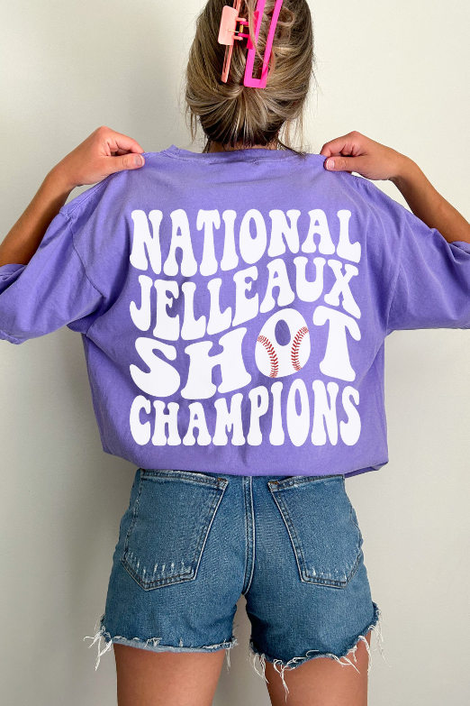 woman wearing a purple t-shirt with a text graphic saying "national jelleaux shot champions"
